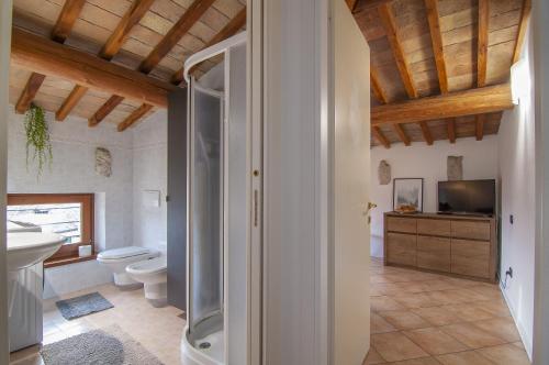 a bathroom with a toilet and a sink and a television at Residence Belvedere ristrutturato vista Wifi in Caprino Veronese
