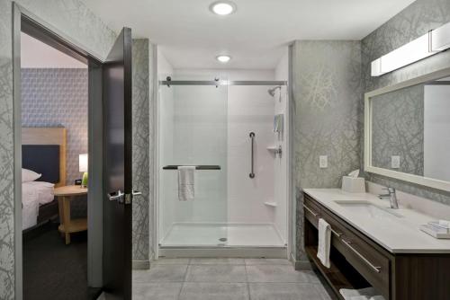 a bathroom with a shower and a sink at Home2 Suites By Hilton Grand Rapids North in Grand Rapids