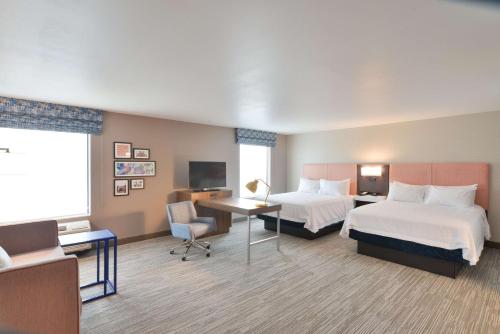 a hotel room with two beds and a desk at Hampton Inn & Suites Menomonie-UW Stout in Menomonie