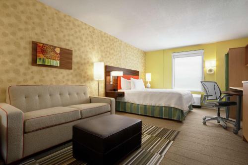 エルコにあるHome2 Suites By Hilton Elkoのベッドとソファ付きのホテルルーム