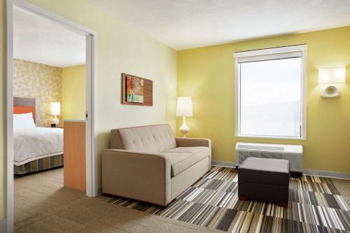 a hotel room with a chair and a bed at Home2 Suites By Hilton Elko in Elko