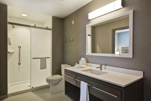 a bathroom with a sink and a toilet and a mirror at Home2 Suites by Hilton Queensbury Lake George in Queensbury