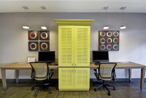 a yellow office with two desks and two chairs at Home2 Suites by Hilton Queensbury Lake George in Queensbury