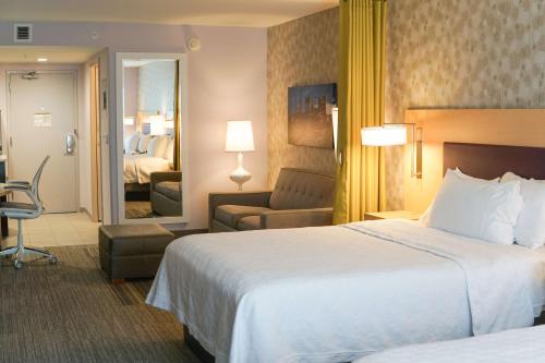 a hotel room with a bed and a living room at Home2 Suites By Hilton Winston-Salem Hanes Mall in Winston-Salem