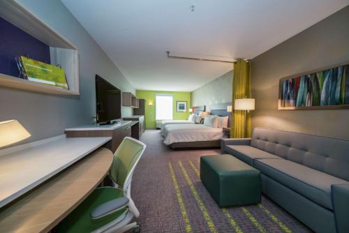 Habitación de hotel con cama y sofá en Home2 Suites By Hilton Jackson Flowood Airport Area en Flowood