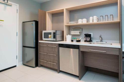 a kitchen with a refrigerator and a sink at Home2 Suites By Hilton Jackson Flowood Airport Area in Flowood