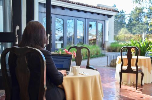 a woman sitting at a table with a laptop at Hilton Guatemala City, Guatemala in Guatemala