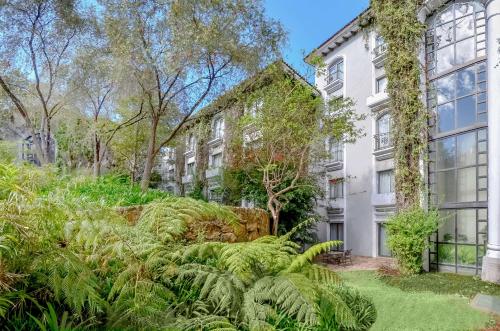 un edificio de apartamentos con plantas delante en Hilton Guatemala City, Guatemala, en Guatemala