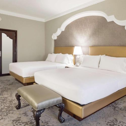 a hotel room with two beds and a chair at Hilton Guatemala City, Guatemala in Guatemala