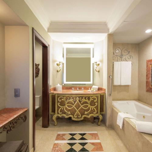 a bathroom with a tub and a sink with a mirror at Hilton Guatemala City, Guatemala in Guatemala