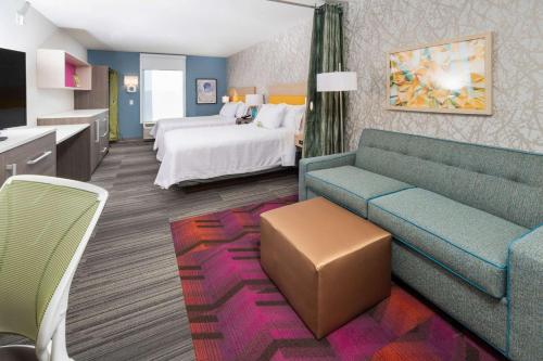 a hotel room with a bed and a couch at Home2 Suites By Hilton Newark Airport in Newark