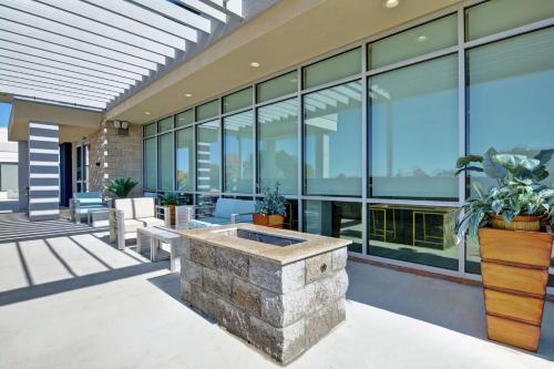 an outdoor patio with a large building with windows at Home2 Suites By Hilton Springdale in Springdale