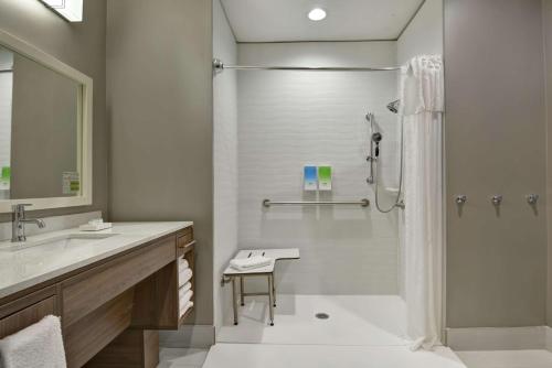 uma casa de banho com um chuveiro e um lavatório. em Home2 Suites By Hilton Springdale em Springdale