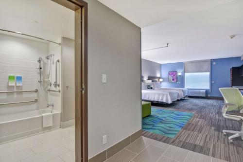 a hotel room with a king bed and a tub at Home2 Suites By Hilton Springdale in Springdale