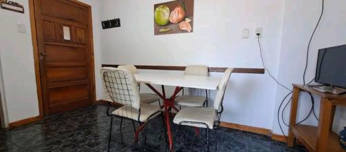 Pokój ze stołem, krzesłami i telewizorem w obiekcie Departamento para 4 personas w mieście Mar de Ajó
