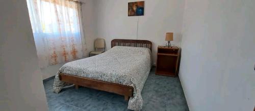 sypialnia z łóżkiem, komodą i oknem w obiekcie Departamento para 4 personas w mieście Mar de Ajó