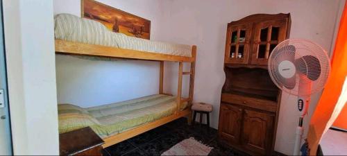 sypialnia z 2 łóżkami piętrowymi i wentylatorem w obiekcie Departamento para 4 personas w mieście Mar de Ajó