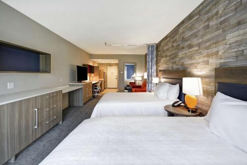 休斯顿Home2 Suites Houston Westchase的一间有两张床和一台平板电视的酒店房间