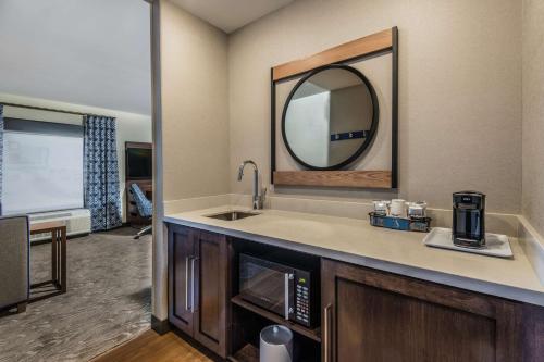 a kitchen with a sink and a mirror over a microwave at Hampton Inn & Suites Fort Wayne Downtown in Fort Wayne