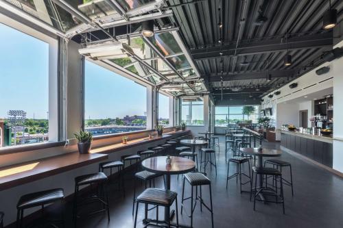 a restaurant with tables and chairs and large windows at Hampton Inn & Suites Fort Wayne Downtown in Fort Wayne