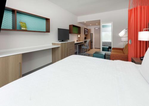 a hotel room with a large bed and a living room at Home2 Suites By Hilton Hagerstown in Hagerstown