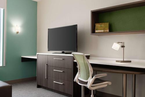 a room with a desk with a monitor and a chair at Home2 Suites By Hilton Houston-Pearland, Tx in Pearland