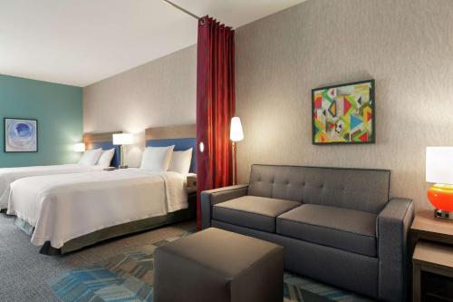 a hotel room with a bed and a couch at Home2 Suites By Hilton Houston-Pearland, Tx in Pearland