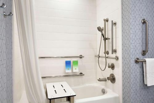 a bathroom with a shower and a white tub at Home2 Suites By Hilton Houston-Pearland, Tx in Pearland