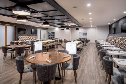 ein Restaurant mit Tischen und Stühlen in einem Raum in der Unterkunft DoubleTree by Hilton Washington DC North/Gaithersburg in Gaithersburg