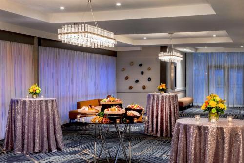 a conference room with two tables with flowers on them at DoubleTree by Hilton Washington DC North/Gaithersburg in Gaithersburg
