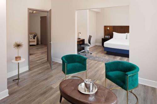 um quarto de hotel com uma cama, uma mesa e cadeiras em Watt Hotel Tapestry Collection by Hilton em Rahway