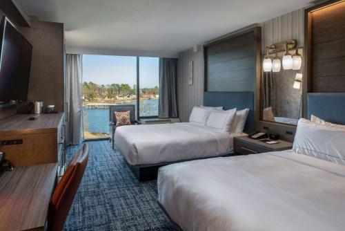 a hotel room with two beds and a view of the water at DoubleTree by Hilton Hot Springs in Hot Springs