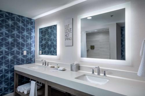 Baño con 2 lavabos y espejo en DoubleTree by Hilton Hot Springs en Hot Springs