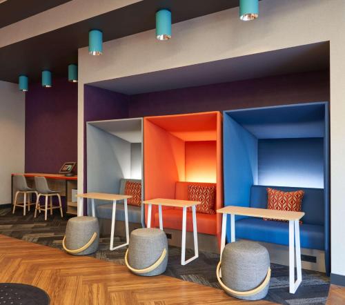 a waiting room with tables and stools at Tru By Hilton Fort Lauderdale Downtown-Flagler Village in Fort Lauderdale