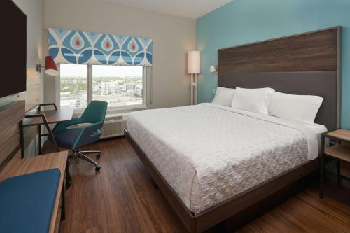 a bedroom with a bed and a desk and a chair at Tru By Hilton Fort Lauderdale Downtown-Flagler Village in Fort Lauderdale