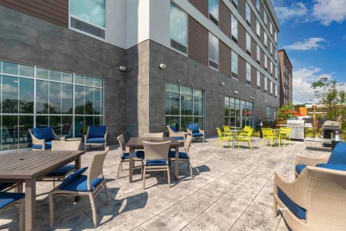 a patio with tables and chairs in front of a building at Hilton Garden Inn By Hilton Fort Wayne North in Sunnybrook Acres