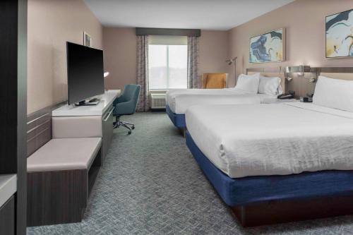 a hotel room with two beds and a flat screen tv at Hilton Garden Inn By Hilton Fort Wayne North in Sunnybrook Acres