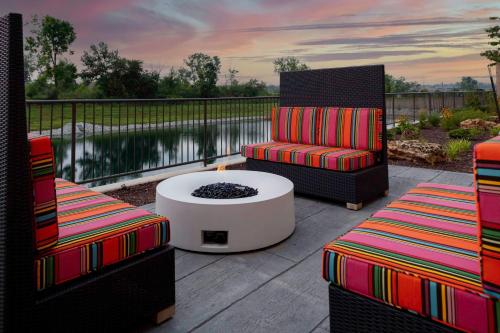 a patio with two chairs and a table and a fire pit at Home2 Suites By Hilton Fort Wayne North in Sunnybrook Acres