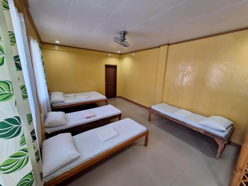 a room with three beds in a room at Agta Beach Resort in Biliran