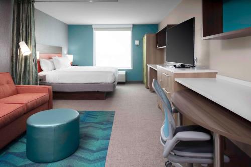 Habitación de hotel con cama y TV en Home2 Suites By Hilton Fort Wayne North, en Sunnybrook Acres