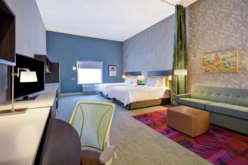 pokój hotelowy z łóżkiem i telewizorem w obiekcie Home2 Suites by Hilton Wichita Northeast w mieście Wichita