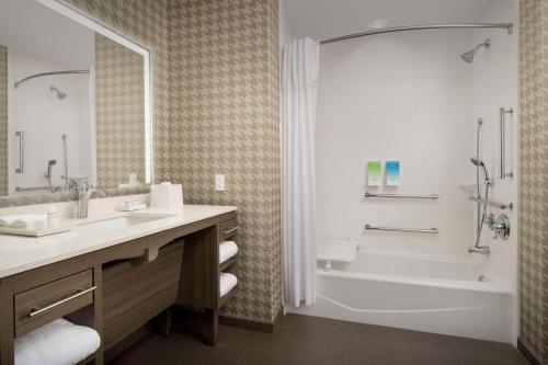 y baño con bañera, lavamanos y ducha. en Home2 Suites By Hilton Clovis Fresno Airport en Clovis