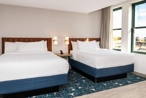 a hotel room with two beds and a window at Hilton Garden Inn Flint Downtown in Flint
