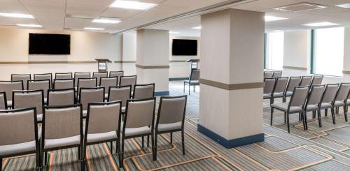 a row of chairs in a room with screens at Hilton Garden Inn Flint Downtown in Flint
