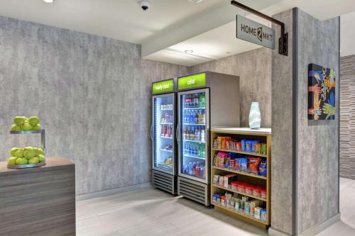 a grocery store with two refrigerators and a shelf of drinks at Home2 Suites By Hilton Jacksonville South St Johns Town Ctr in Jacksonville