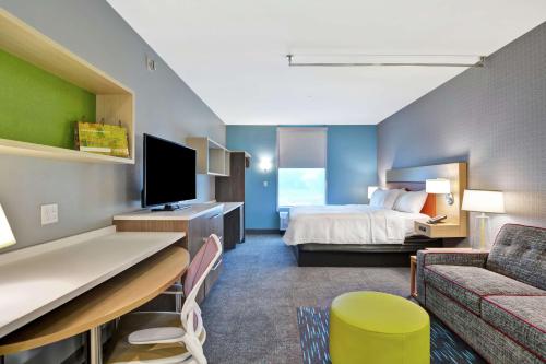 a hotel room with a bed and a couch at Home2 Suites By Hilton Jacksonville South St Johns Town Ctr in Jacksonville