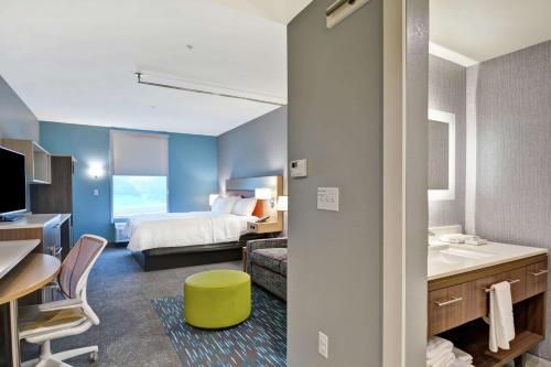 a hotel room with a bed and a bathroom at Home2 Suites By Hilton Jacksonville South St Johns Town Ctr in Jacksonville