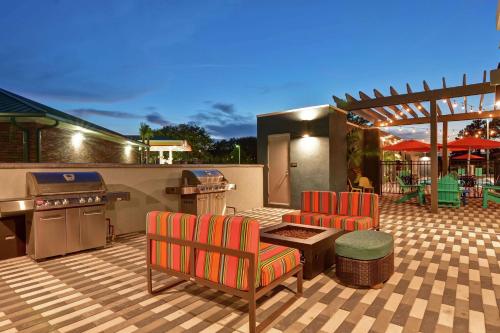 a patio with a grill and two chairs and a table at Home2 Suites By Hilton Jacksonville South St Johns Town Ctr in Jacksonville