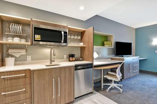 a kitchen with a sink and a desk with a computer at Home2 Suites By Hilton Jacksonville South St Johns Town Ctr in Jacksonville