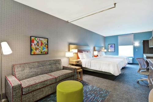 ジャクソンビルにあるHome2 Suites By Hilton Jacksonville South St Johns Town Ctrのベッドとソファ付きのホテルルーム